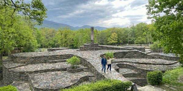 Visitors exploring a stone ruin and cultural landmark surrounded by greenery in the Catskills.
