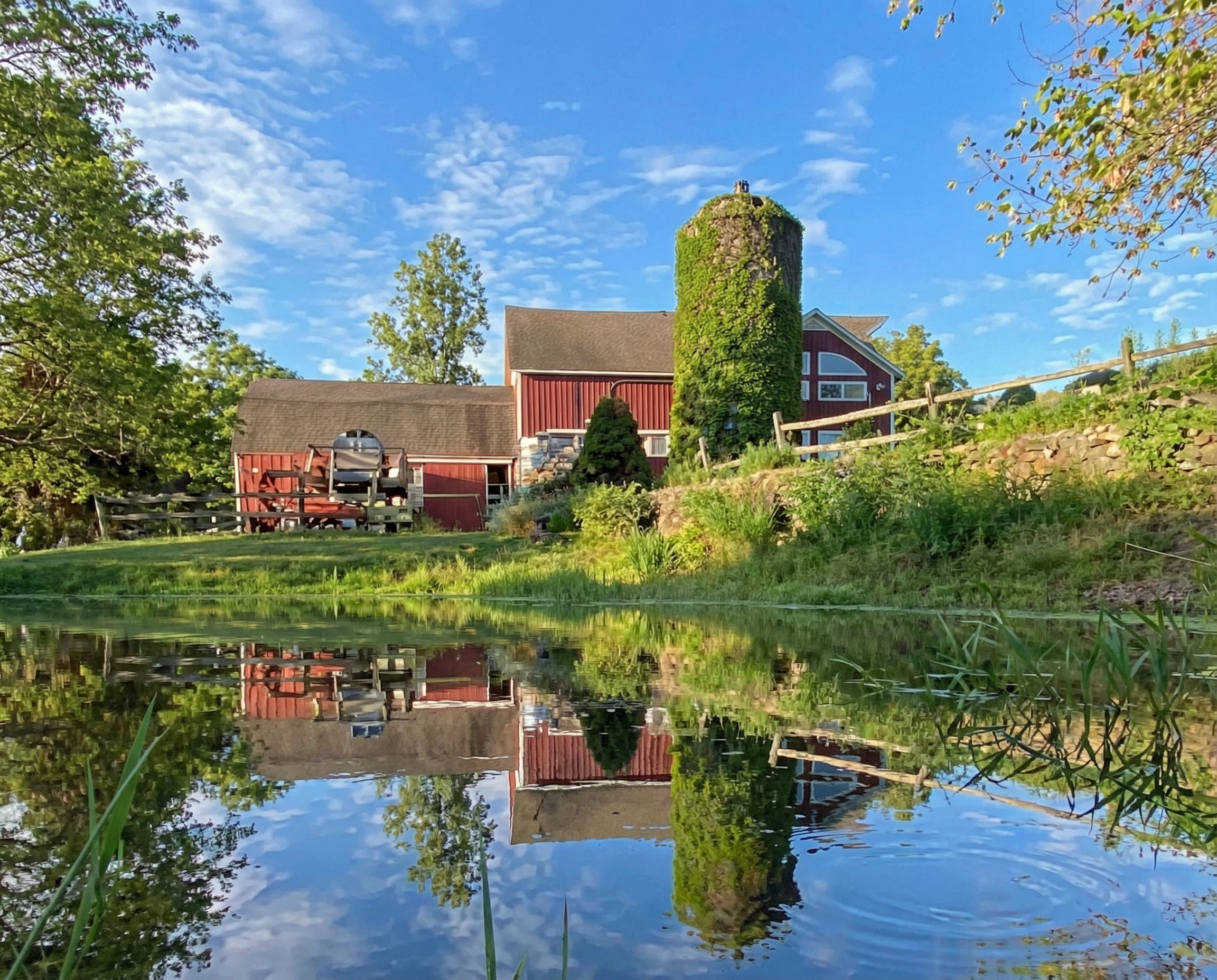 Visitors walking through a light-filled contemporary art museum in the Hamptons, with large-scale abstract paintings displayed along white gallery walls beneath a vaulted wood ceiling.